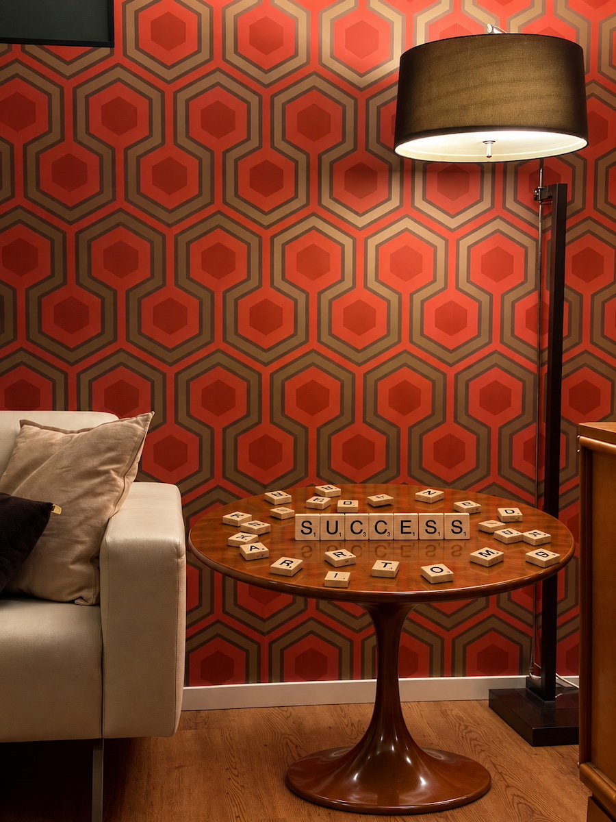 Retro lounge with orange patterned wallpaper and wooden letters spelling success