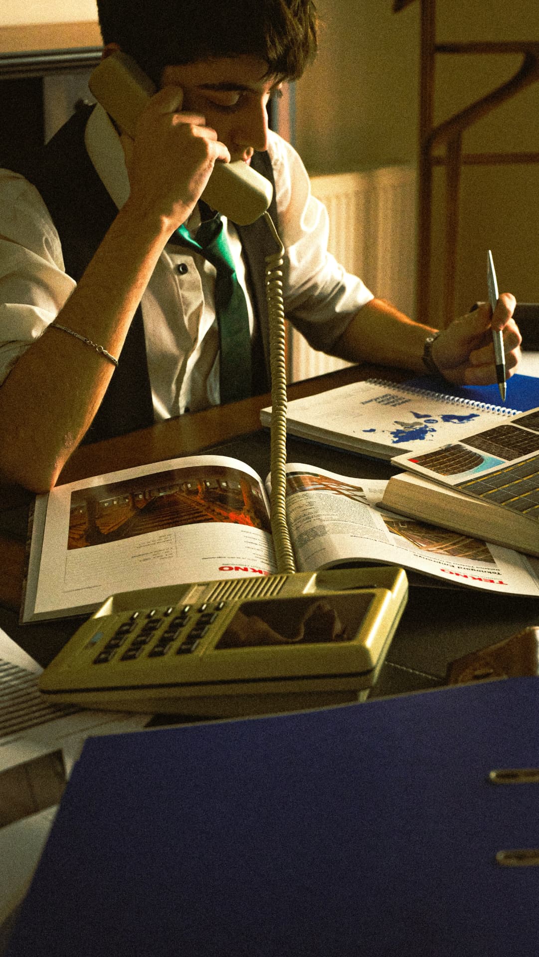 Designer sketching ideas at a desk while on the telephone